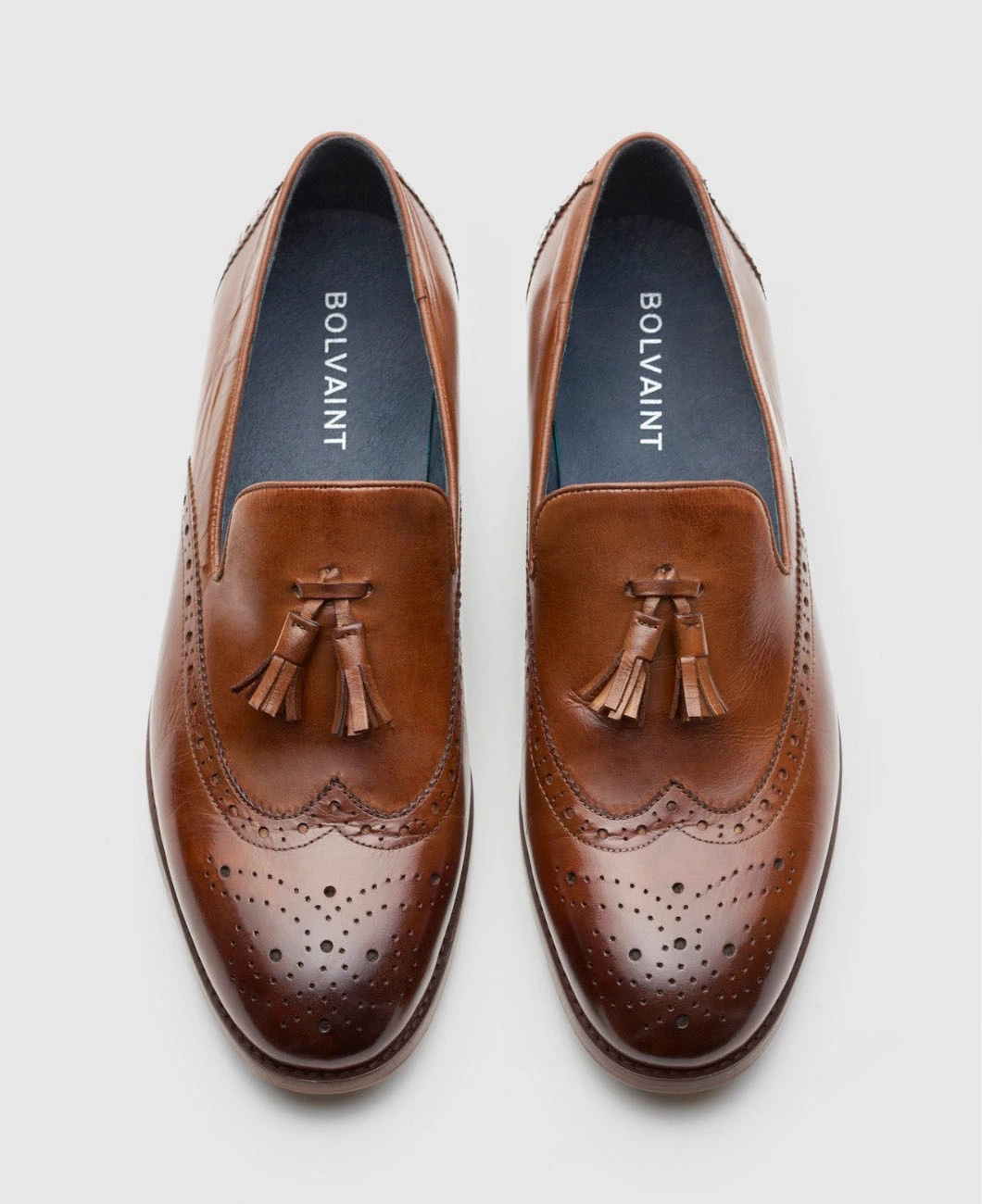 A brown leather loafer featuring decorative tassels, showcasing a classic and elegant design suitable for formal occasions