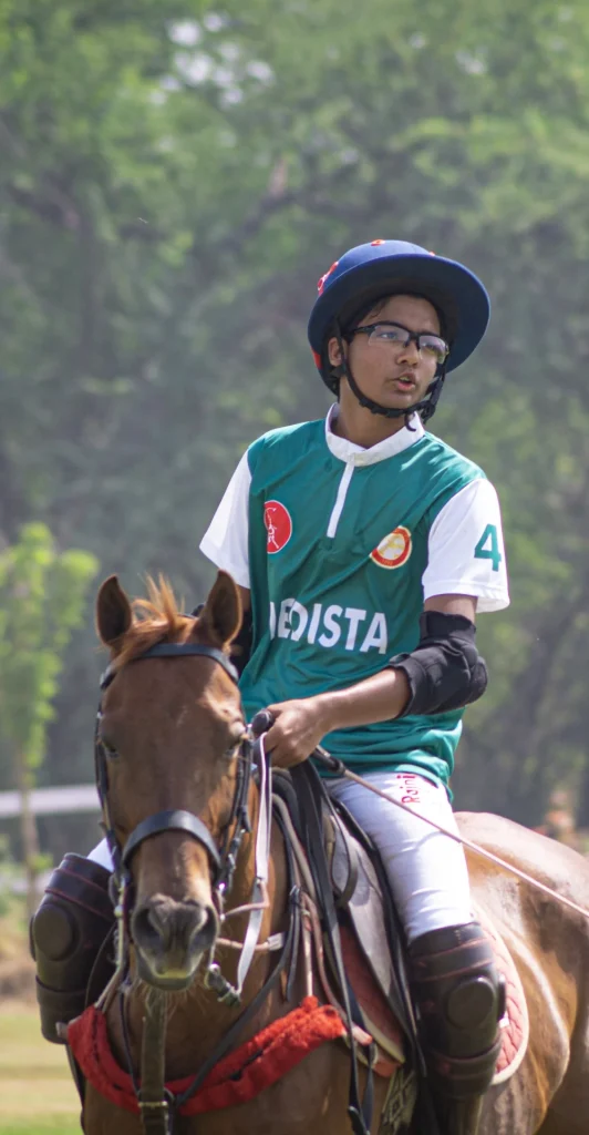 A man playing polo, confidently riding a horse across an open field, showcasing skill, teamwork, and the strong bond between rider and animal.