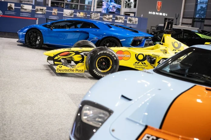 A blue and orange race car is showcased prominently, highlighting its sleek design and vibrant colors.