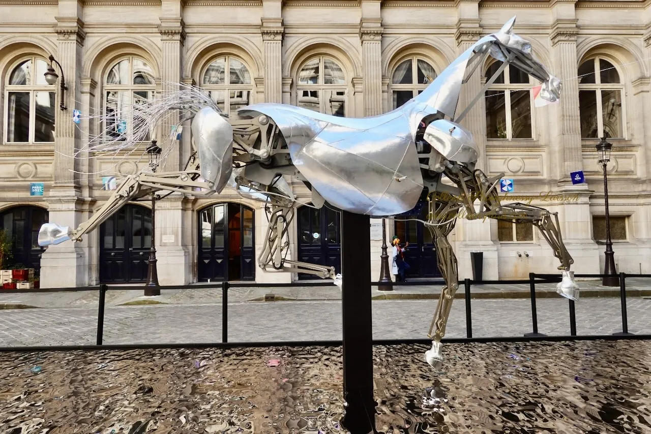 A majestic horse sculpture stands proudly in front of a grand building, showcasing artistry and elegance